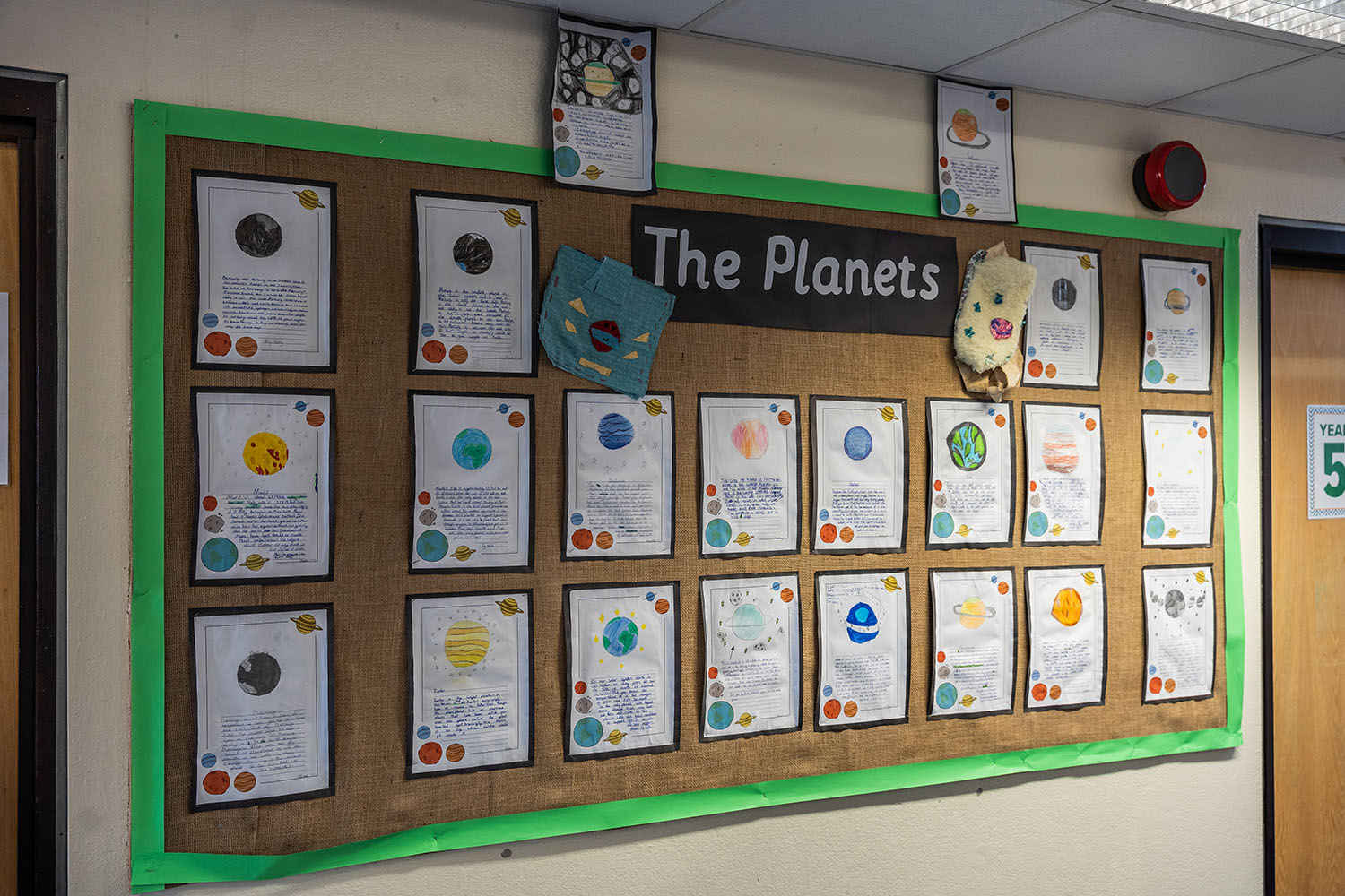 A display of written work on a wall with the title: The Planets